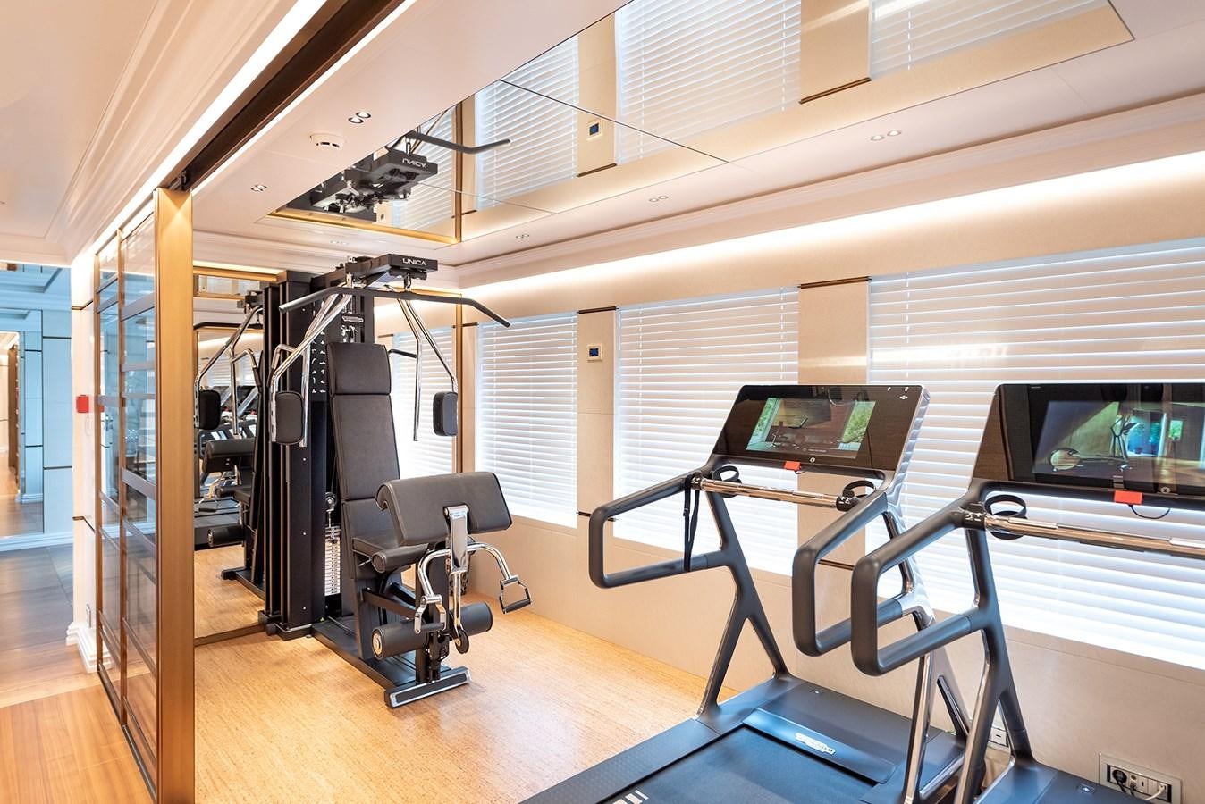 a room with treadmills and treadmills aboard M55 Yacht for Sale