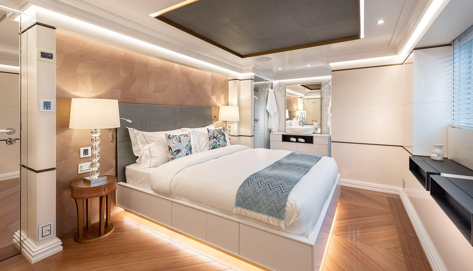 a bedroom with a bed and a desk aboard M55 Yacht for Sale