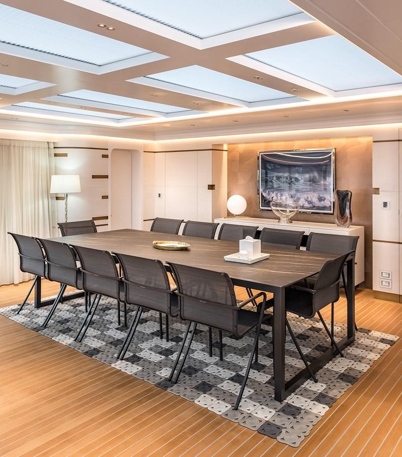 a large room with a table and chairs aboard M55 Yacht for Sale