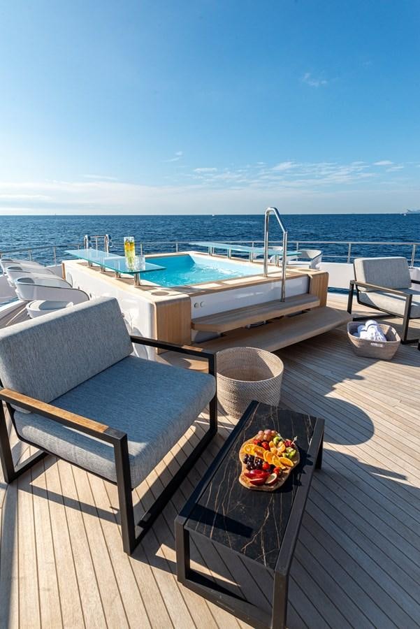 a patio with a table and chairs on it aboard M55 Yacht for Sale