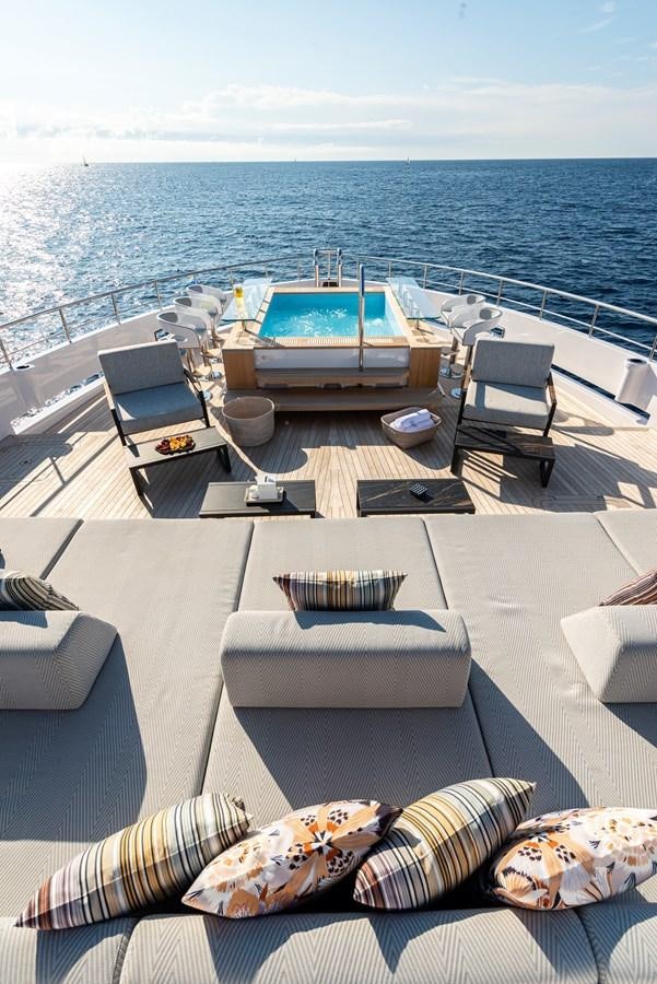 a deck with a pool and chairs on it aboard M55 Yacht for Sale