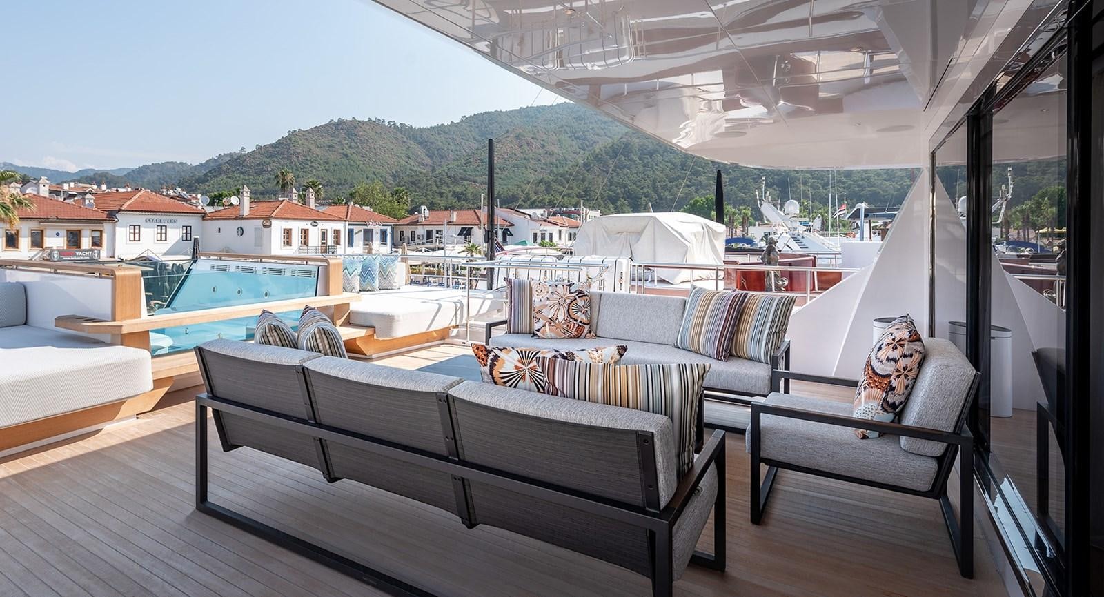 a room with a deck and a view of the water and mountains aboard M55 Yacht for Sale
