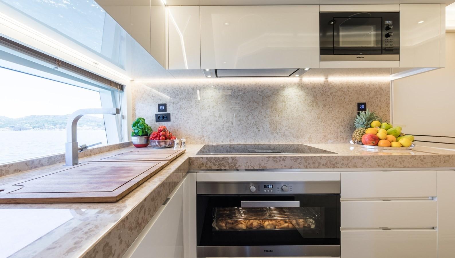 a kitchen with a stove and a window aboard YORAL Yacht for Sale