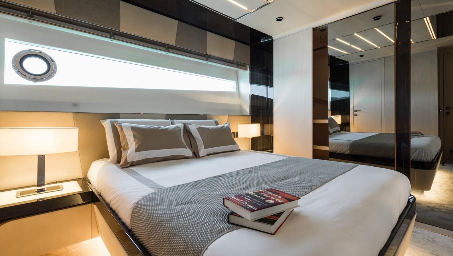 a bed with a book on it aboard YORAL Yacht for Sale