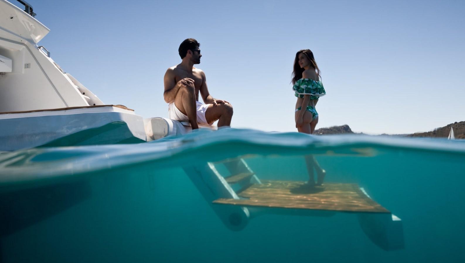 a man and woman sitting on a boat aboard YORAL Yacht for Sale