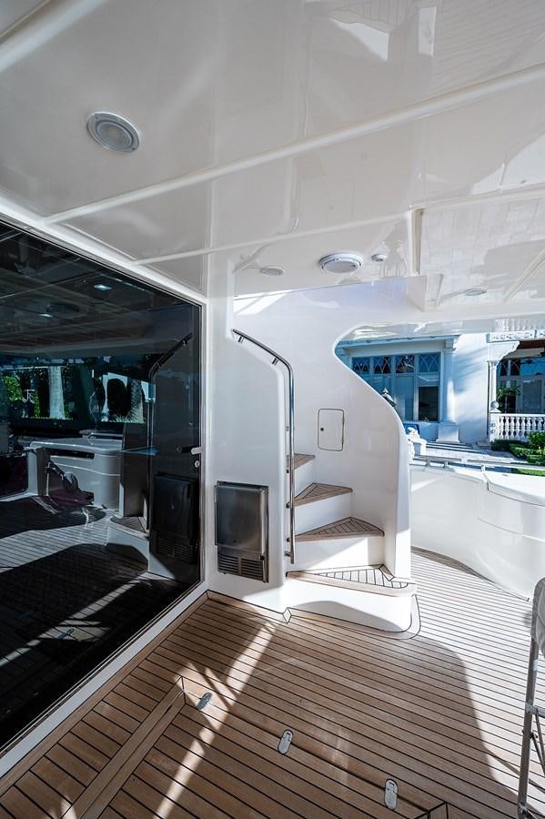 a room with a wood floor and a staircase and a glass door aboard FERRETTI Yacht for Sale