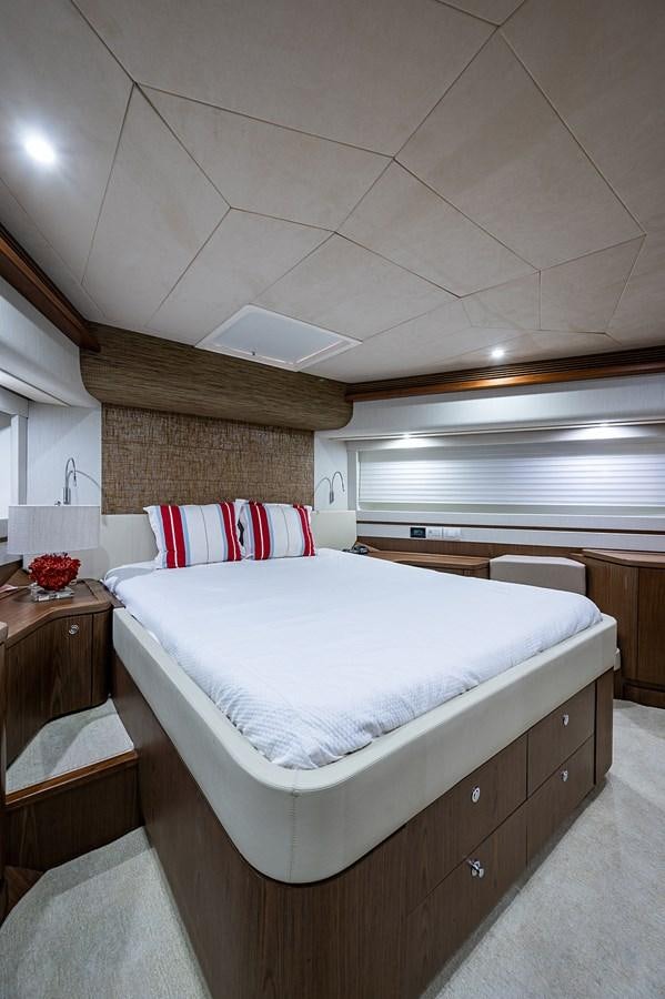 a bedroom with a bed and a window aboard FERRETTI Yacht for Sale