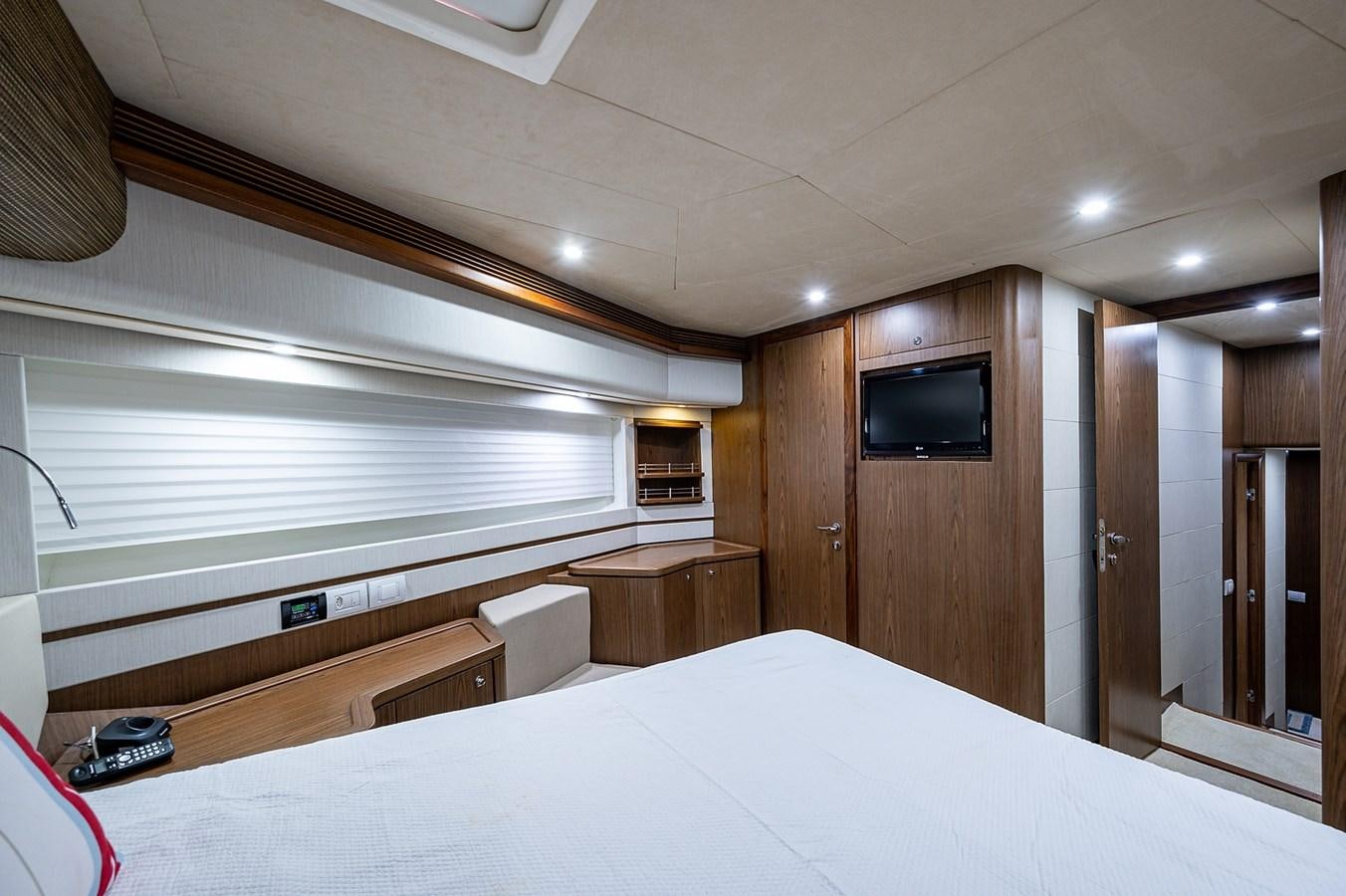 a room with a bed and a television aboard FERRETTI Yacht for Sale