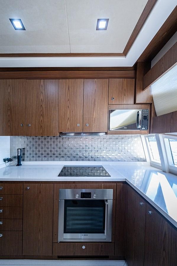 a kitchen with wooden cabinets aboard FERRETTI Yacht for Sale