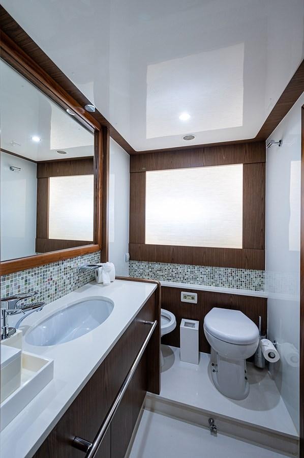 a bathroom with a sink toilet and a mirror aboard FERRETTI Yacht for Sale
