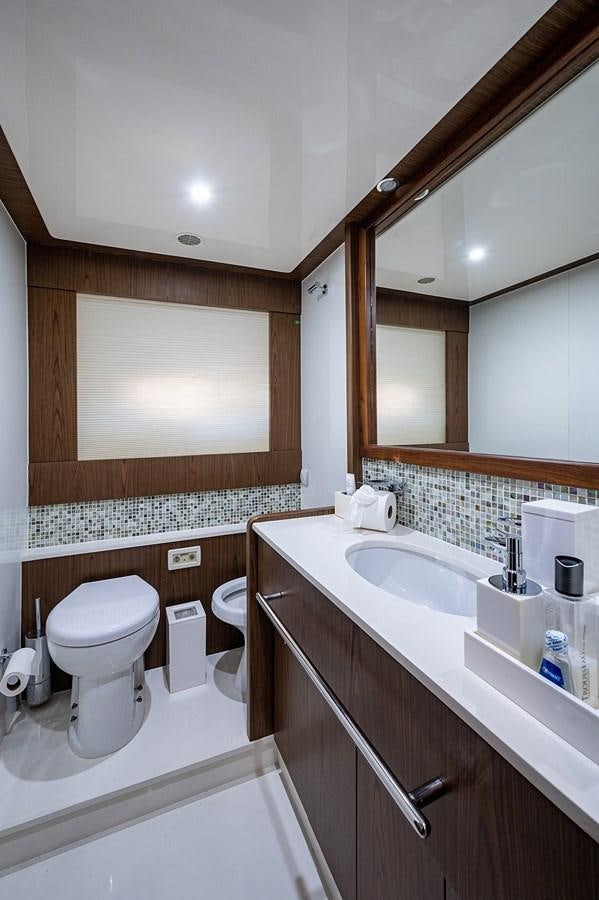 a bathroom with a sink toilet and a mirror aboard FERRETTI Yacht for Sale