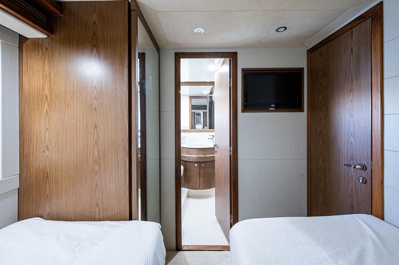 a room with a bed and a television aboard FERRETTI Yacht for Sale