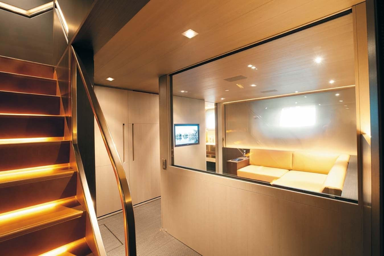 a room with a staircase and a tv on the wall aboard ENTERPRISE Yacht for Sale