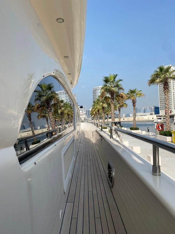 a white building with a railing and palm trees and a blue sky aboard SERDAL Yacht for Sale