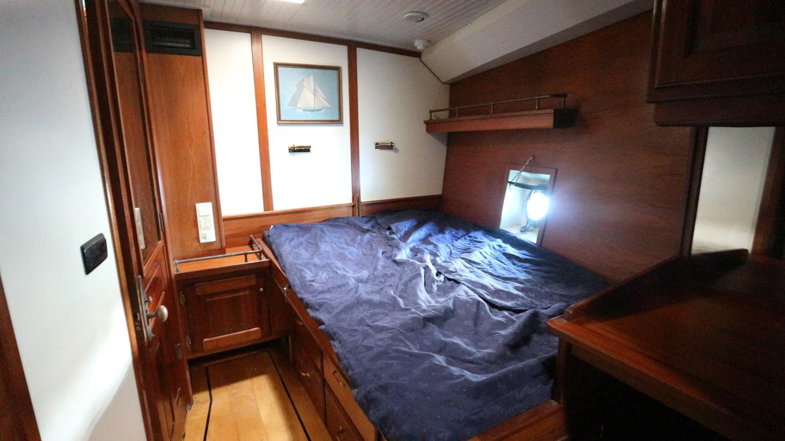 a bedroom with a bed and a lamp on the table aboard ARIES Yacht for Sale