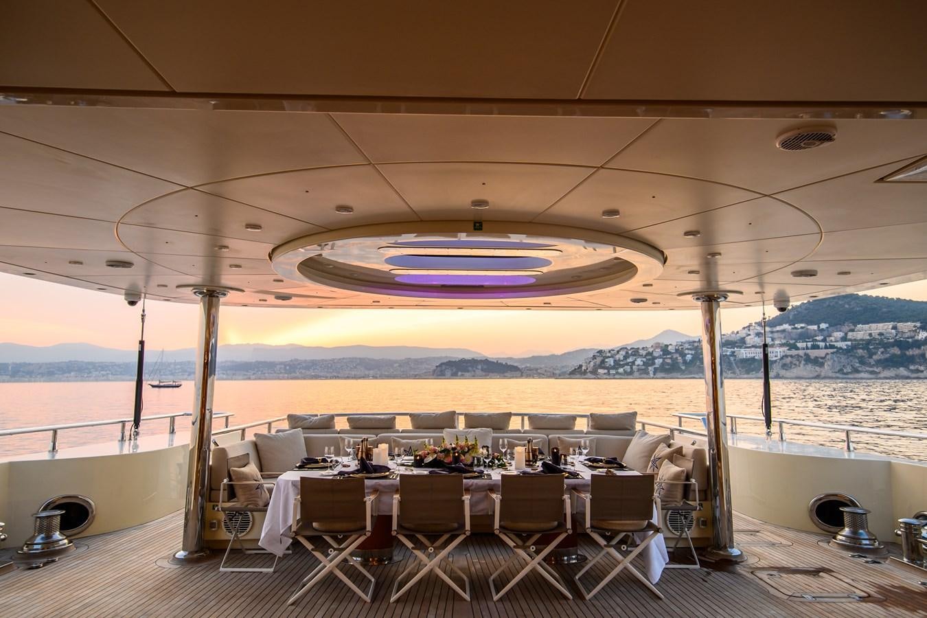 a large outdoor restaurant with a view of mountains and water aboard ARESTEAS Yacht for Sale