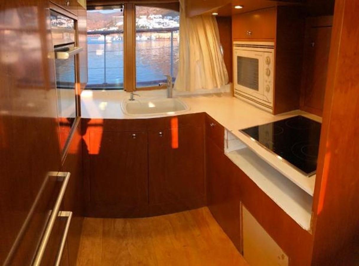 a kitchen with wooden cabinets aboard 1960 CUSTOM CRUISER  Yacht for Sale