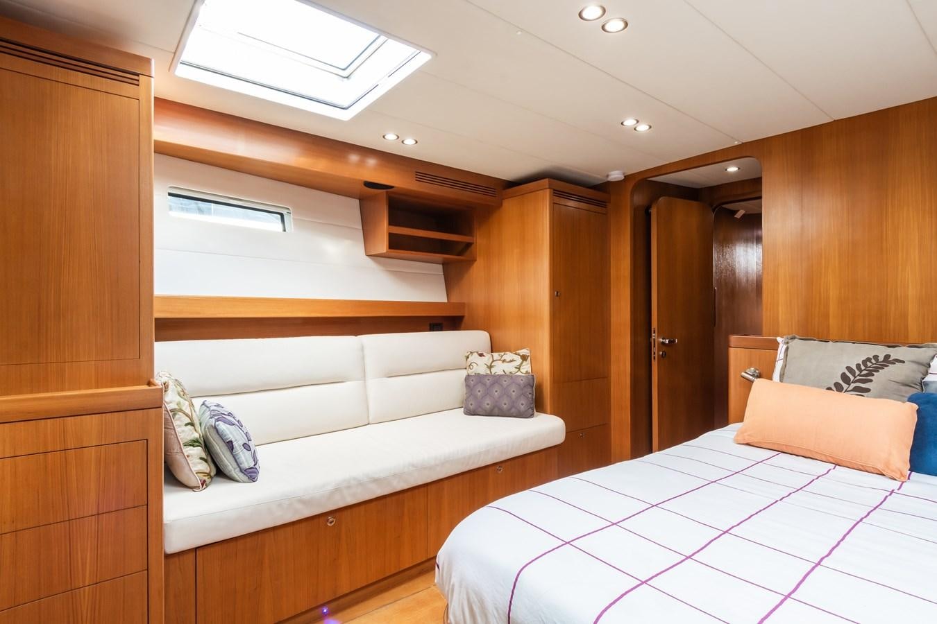 a room with a bed and a wood cabinet aboard SHADOW Yacht for Sale