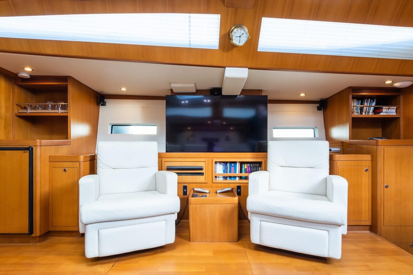 a room with a white couch and a tv aboard SHADOW Yacht for Sale
