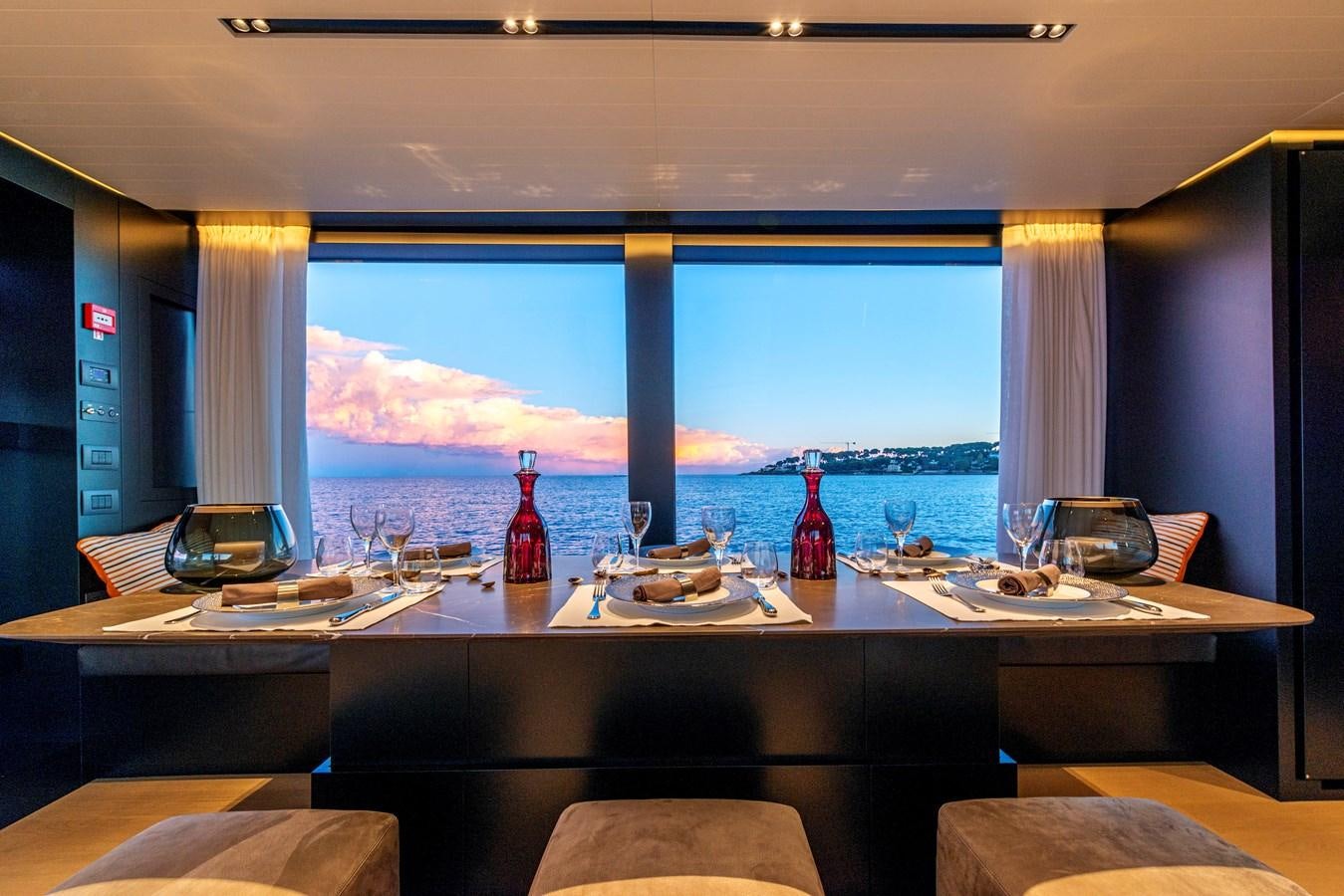 a table with wine bottles on it aboard AMWAJ Yacht for Sale