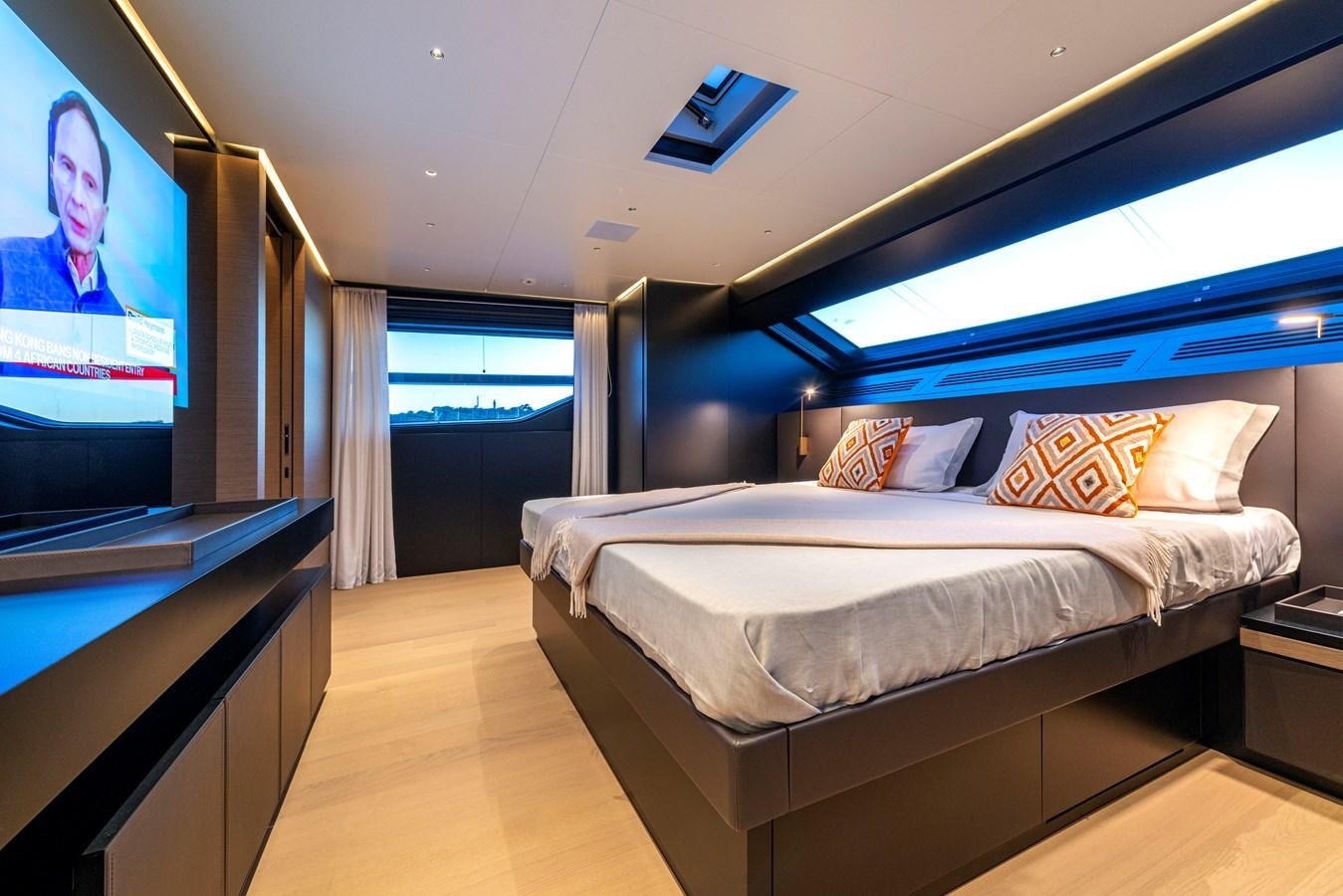 a room with a bed and a tv on the wall aboard AMWAJ Yacht for Sale