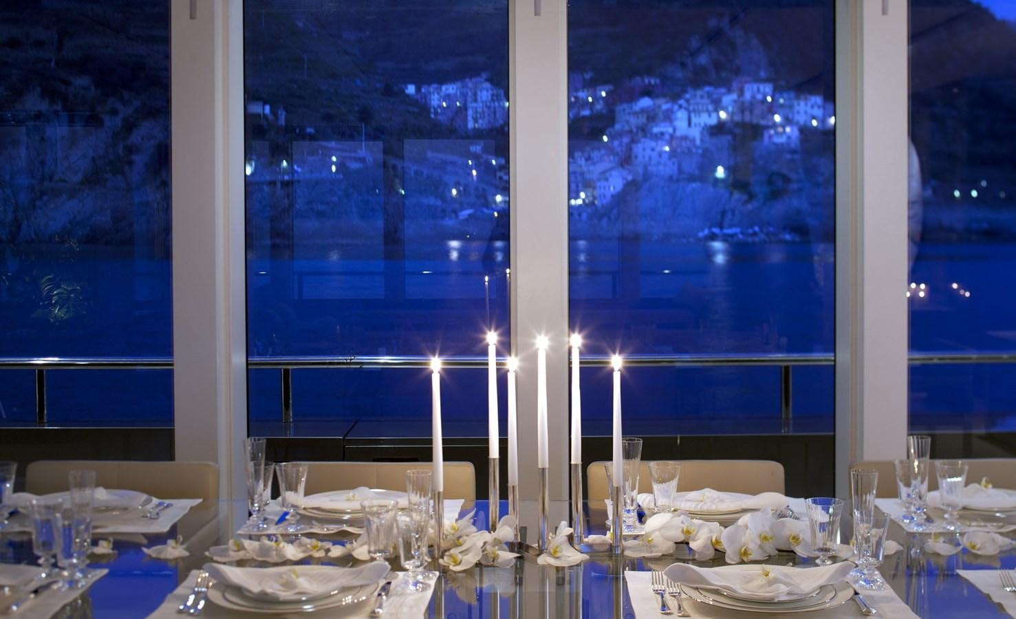 a table with plates and candles aboard STELLA MARIS Yacht for Sale