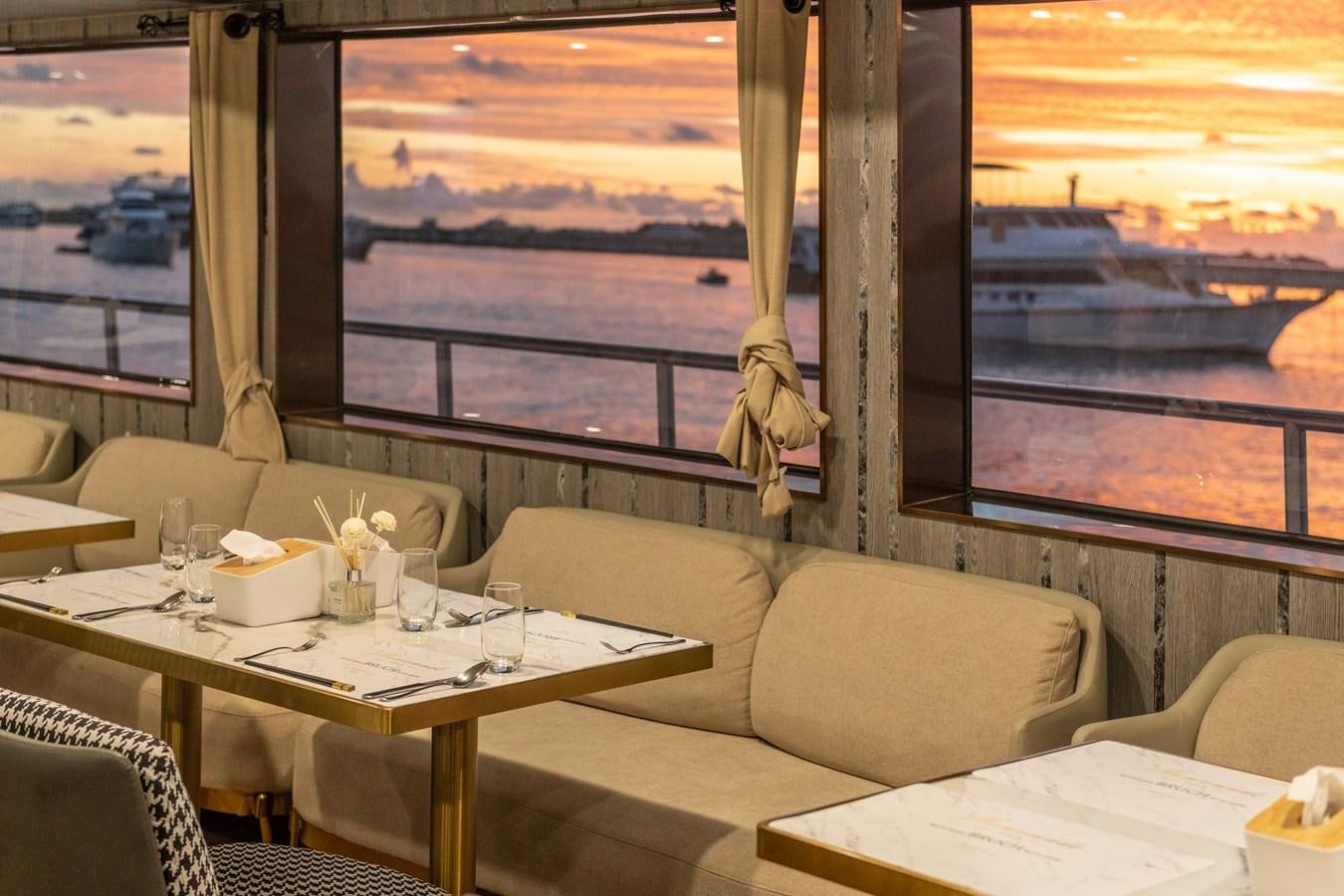 a room with a table and chairs aboard INFINITY X Yacht for Sale