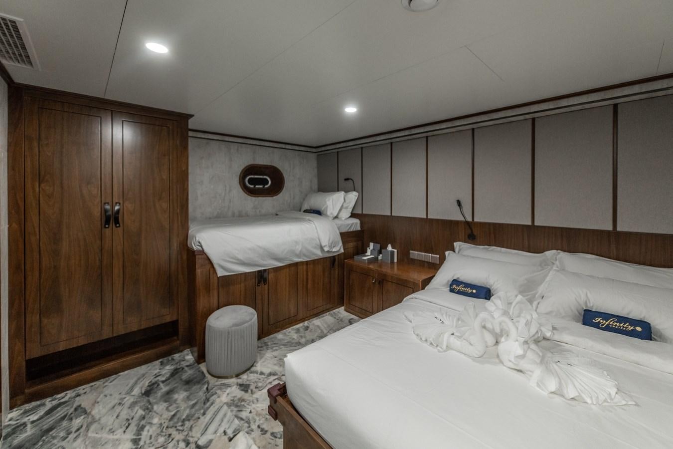a room with a bed and a cupboard aboard INFINITY X Yacht for Sale
