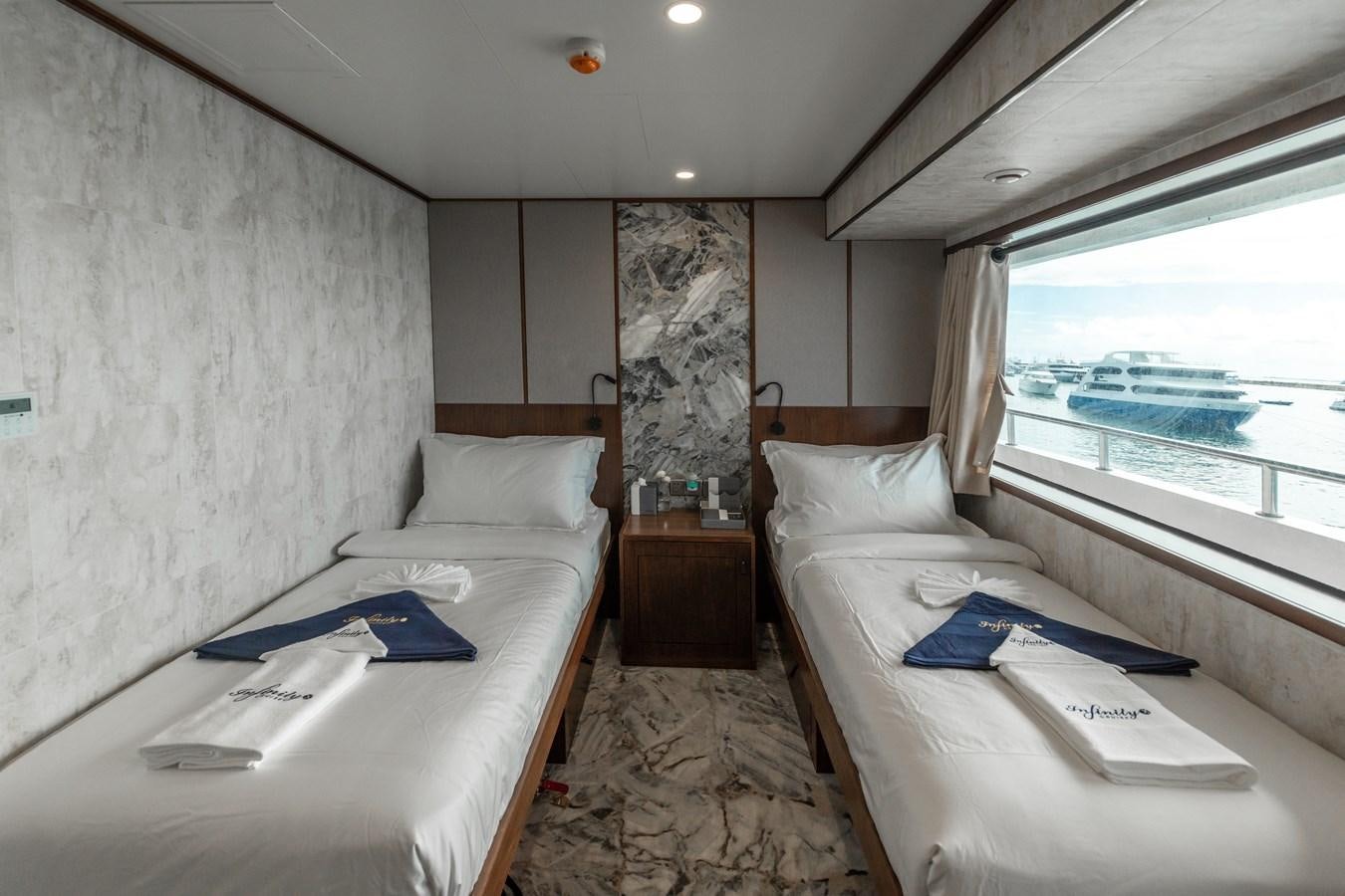 a room with a bed and a window aboard INFINITY X Yacht for Sale