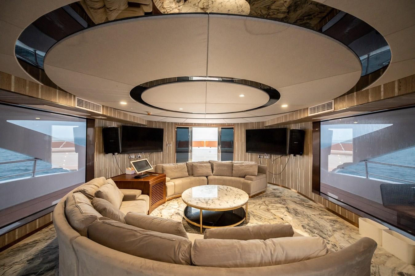 a living room with a large chandelier aboard INFINITY X Yacht for Sale