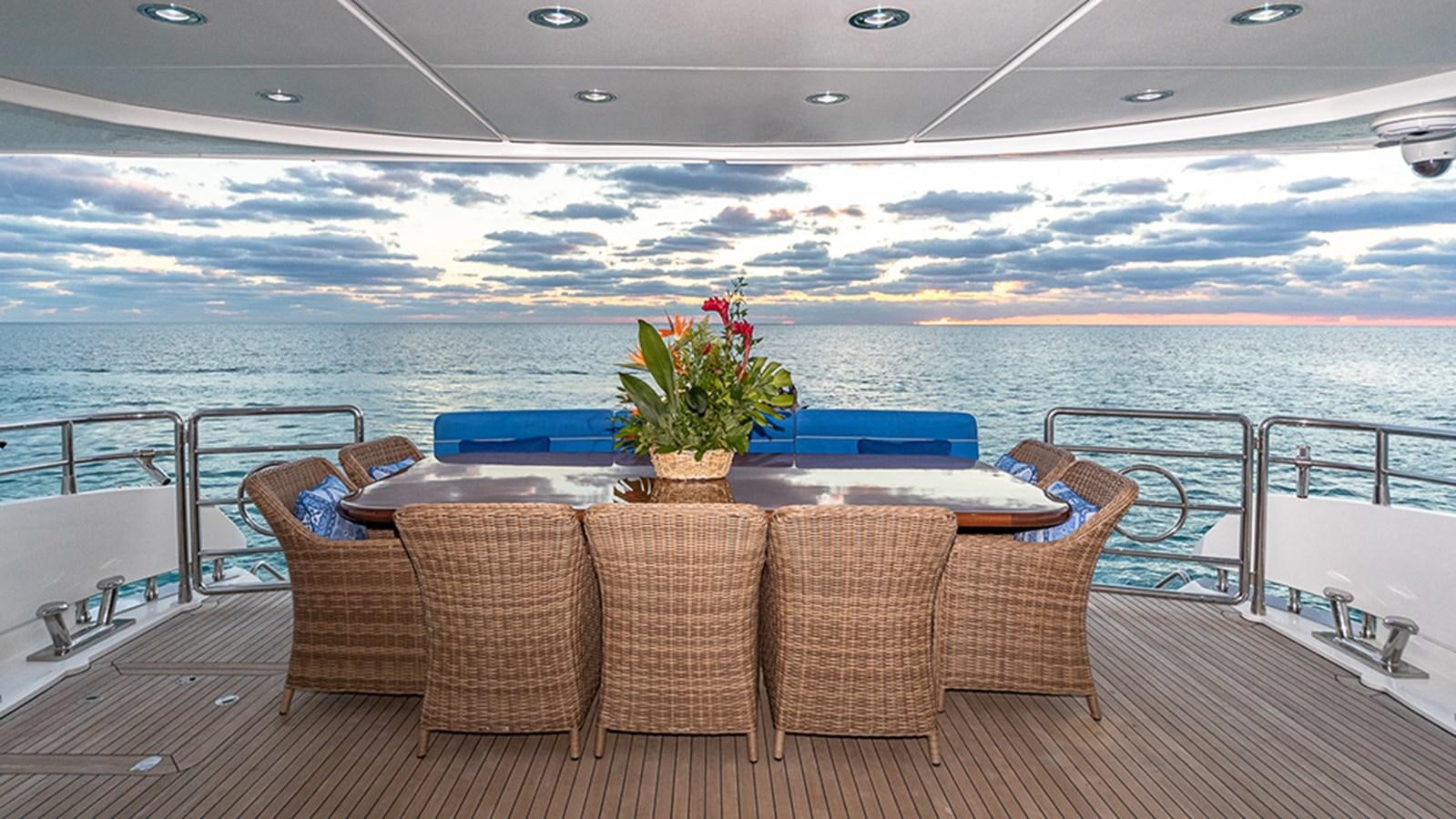 a table on a deck overlooking a body of water aboard KEFI Yacht for Sale