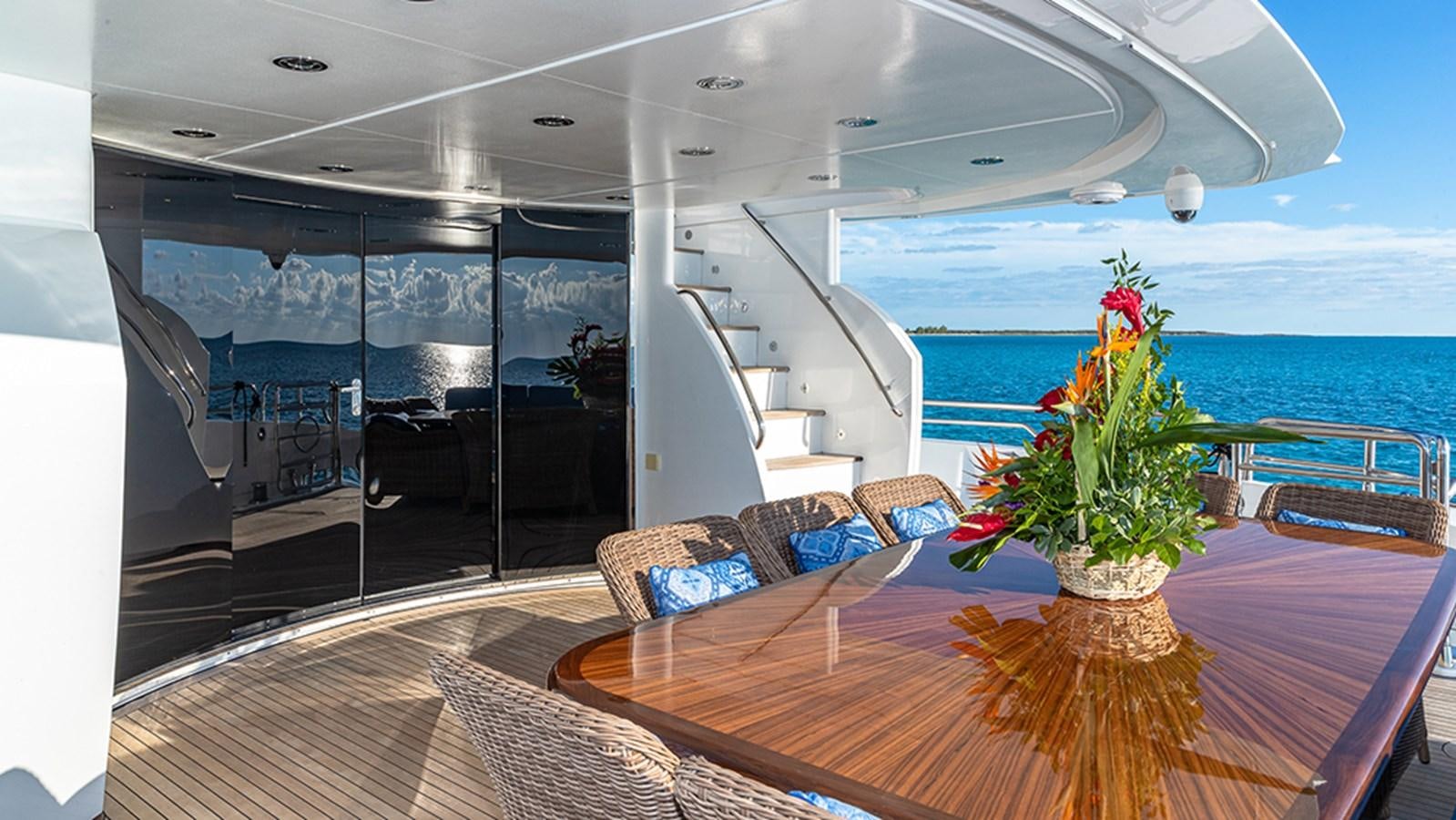 a large room with a table and chairs and a view of the ocean aboard KEFI Yacht for Sale