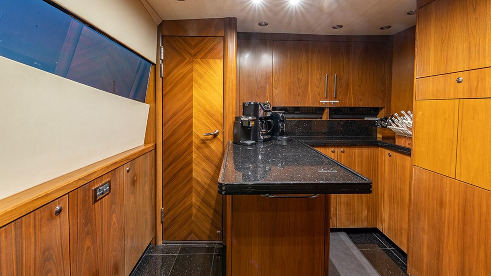a kitchen with wooden cabinets aboard KEFI Yacht for Sale