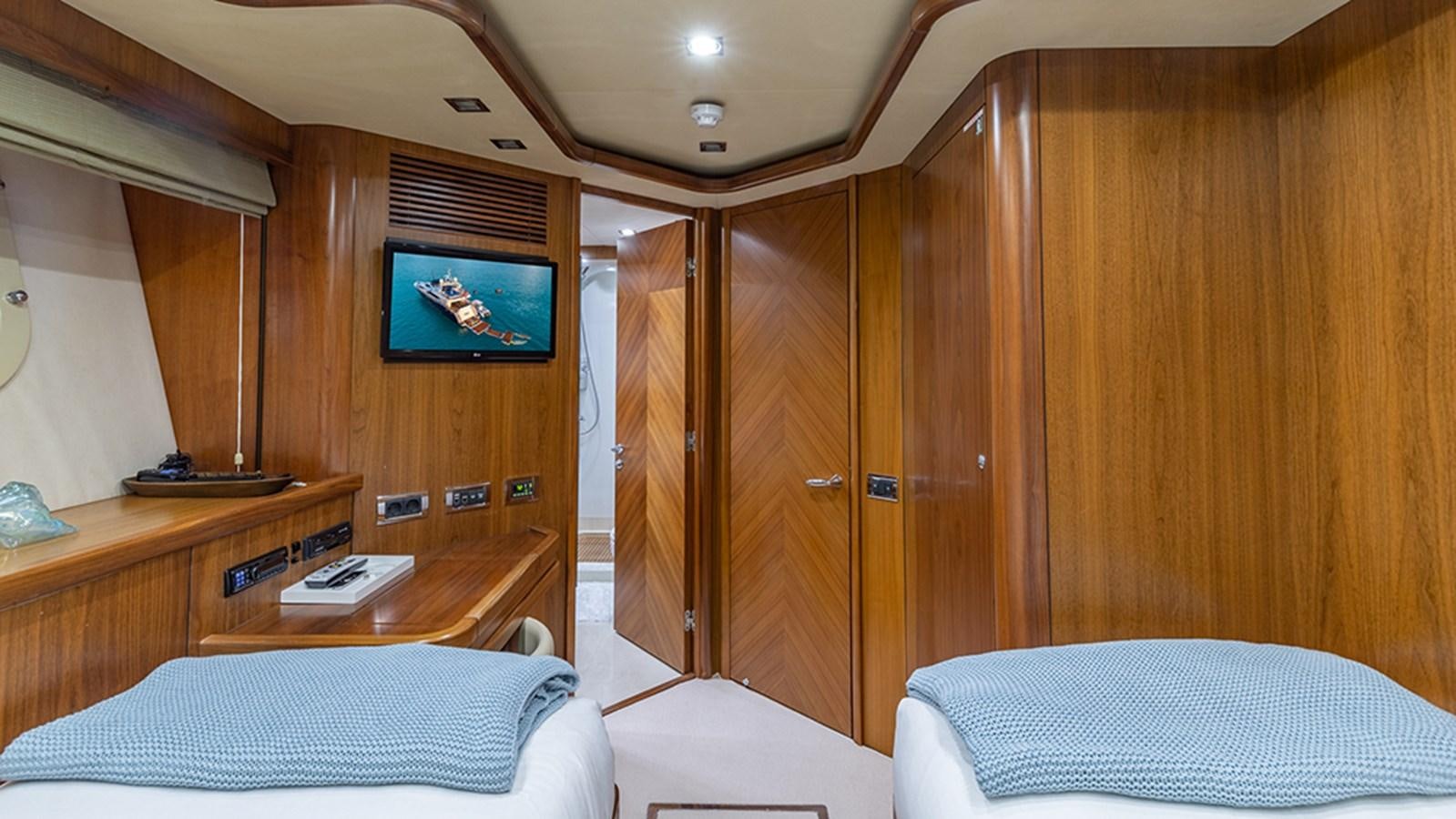 a room with a bed and a tv on the wall aboard KEFI Yacht for Sale