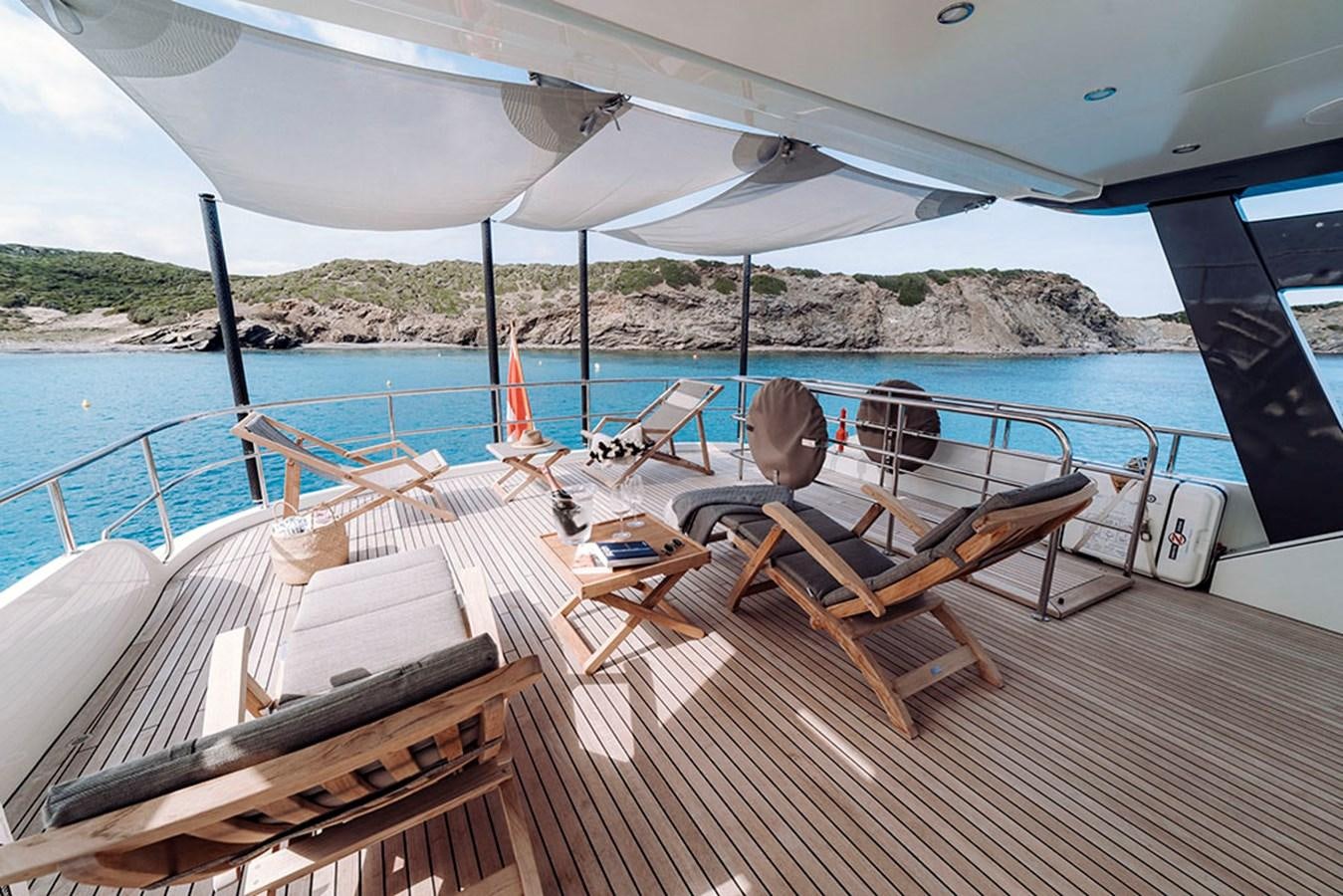 a group of chairs on a deck by a body of water aboard LAS NINAS Yacht for Sale