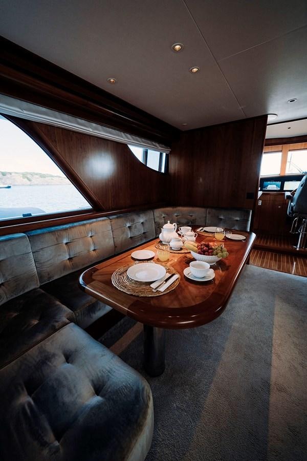 a wood table with plates and food on it aboard LAS NINAS Yacht for Sale