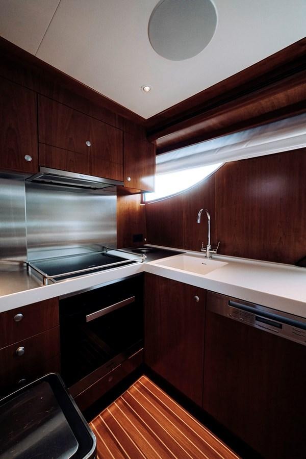 a kitchen with dark wood cabinets aboard LAS NINAS Yacht for Sale