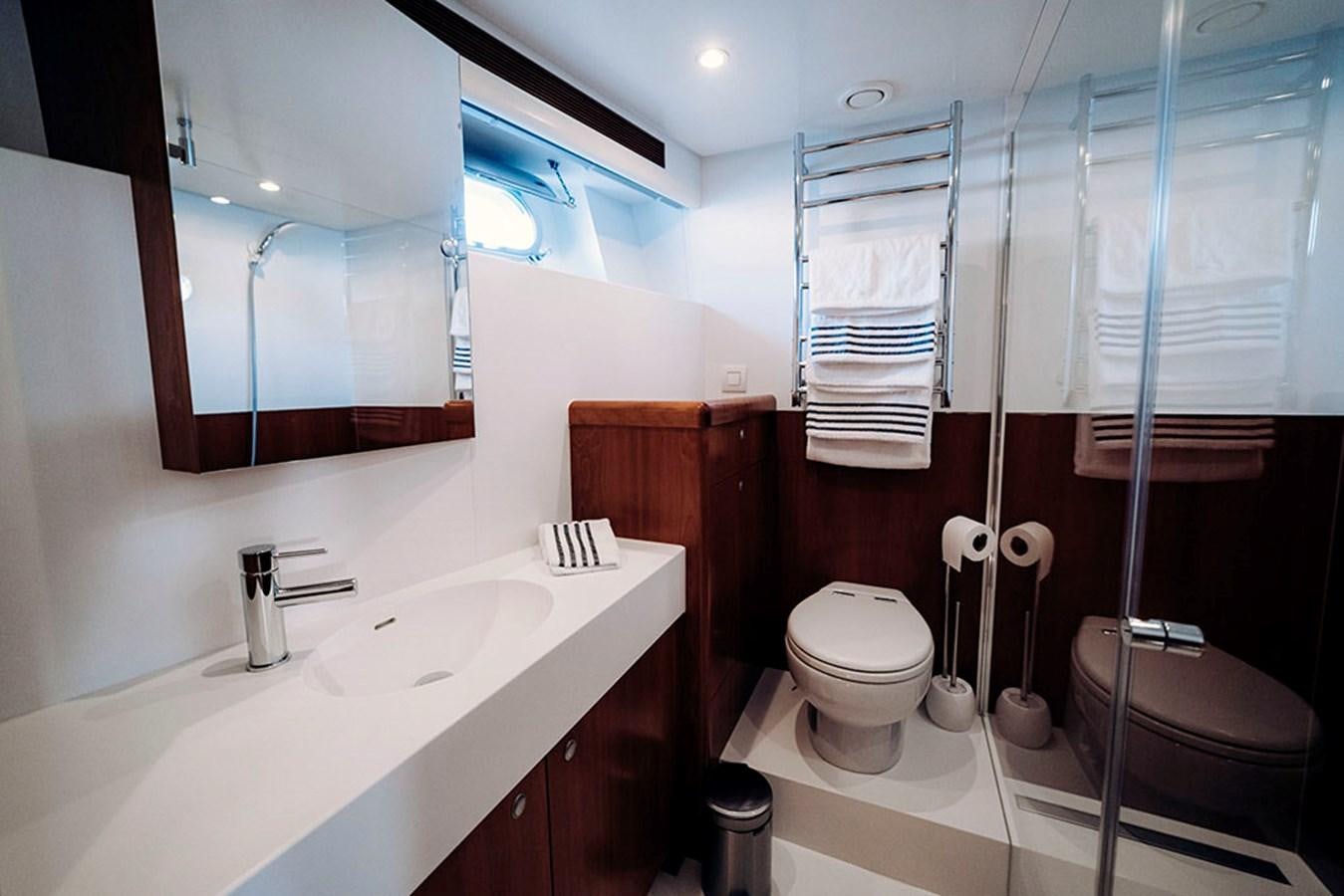 a bathroom with a sink toilet and a mirror aboard LAS NINAS Yacht for Sale
