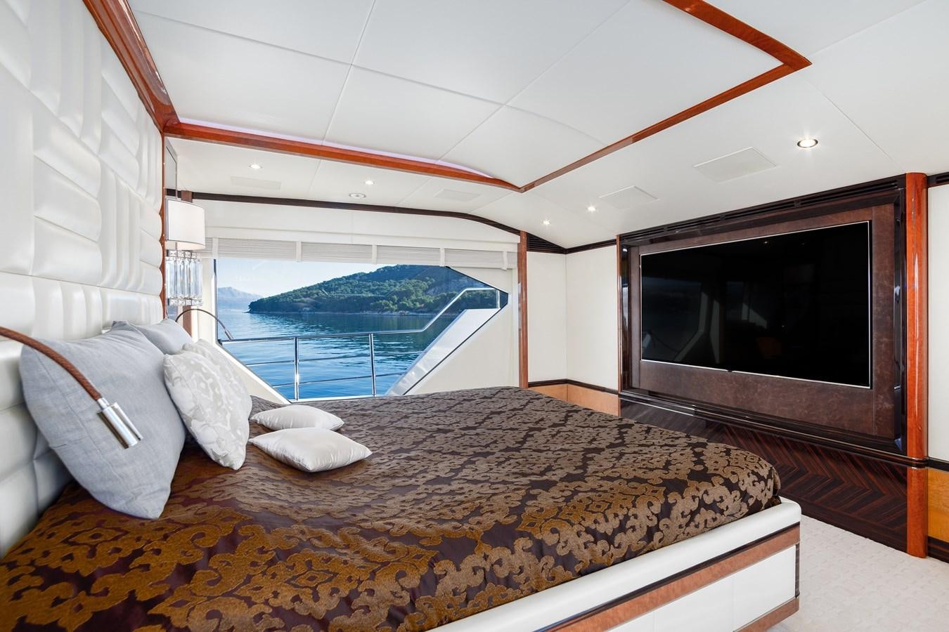 a bed with a television on the wall aboard VARVARA Yacht for Sale