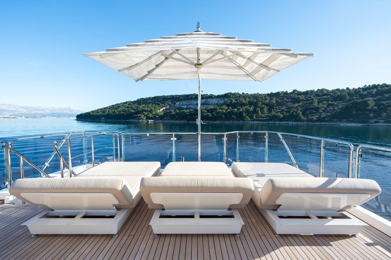 lounge chairs and an umbrella on a boat aboard VARVARA Yacht for Sale