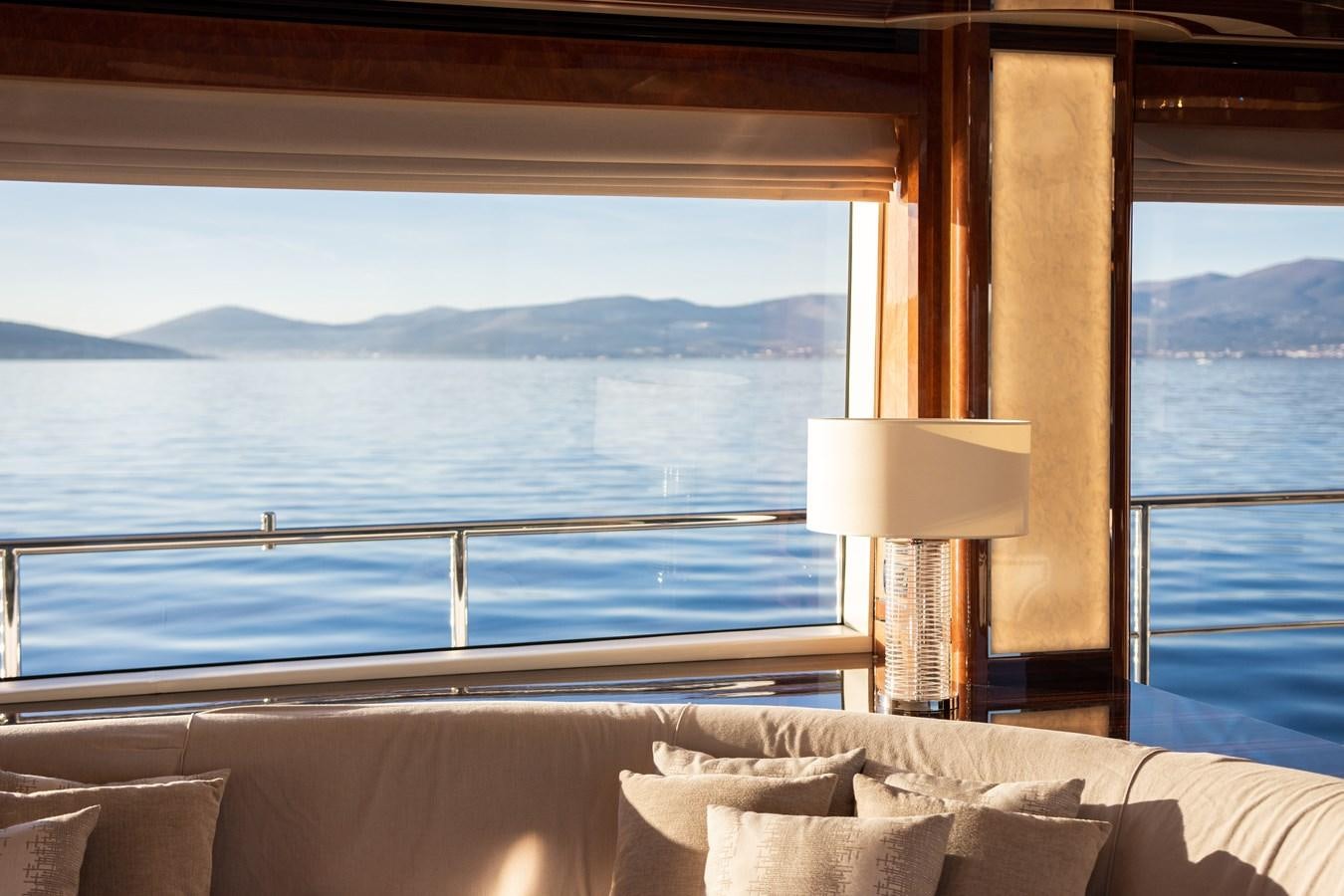 a bed with a window overlooking a body of water aboard VARVARA Yacht for Sale