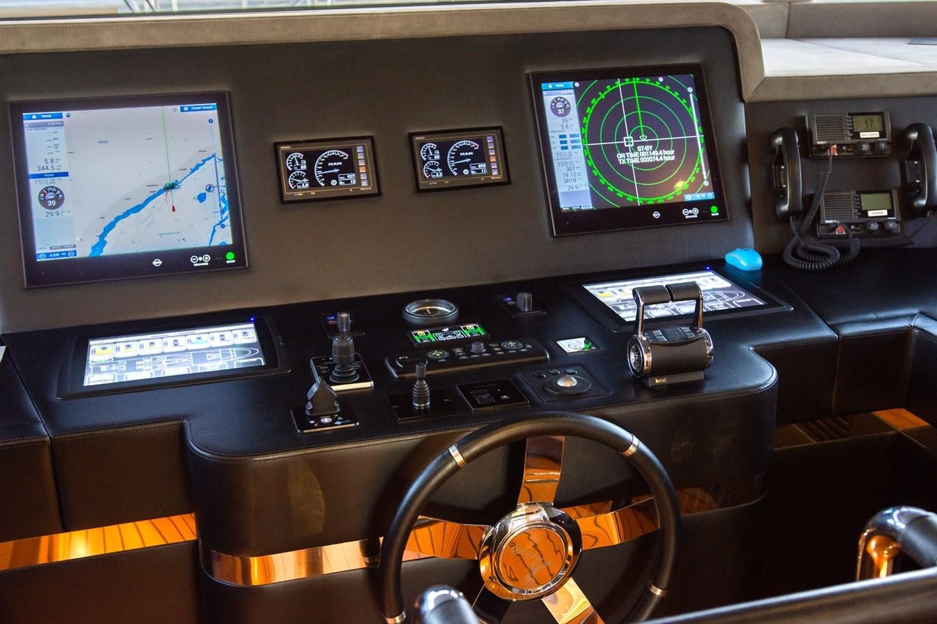 a control panel with a variety of electronics and a large screen aboard VARVARA Yacht for Sale