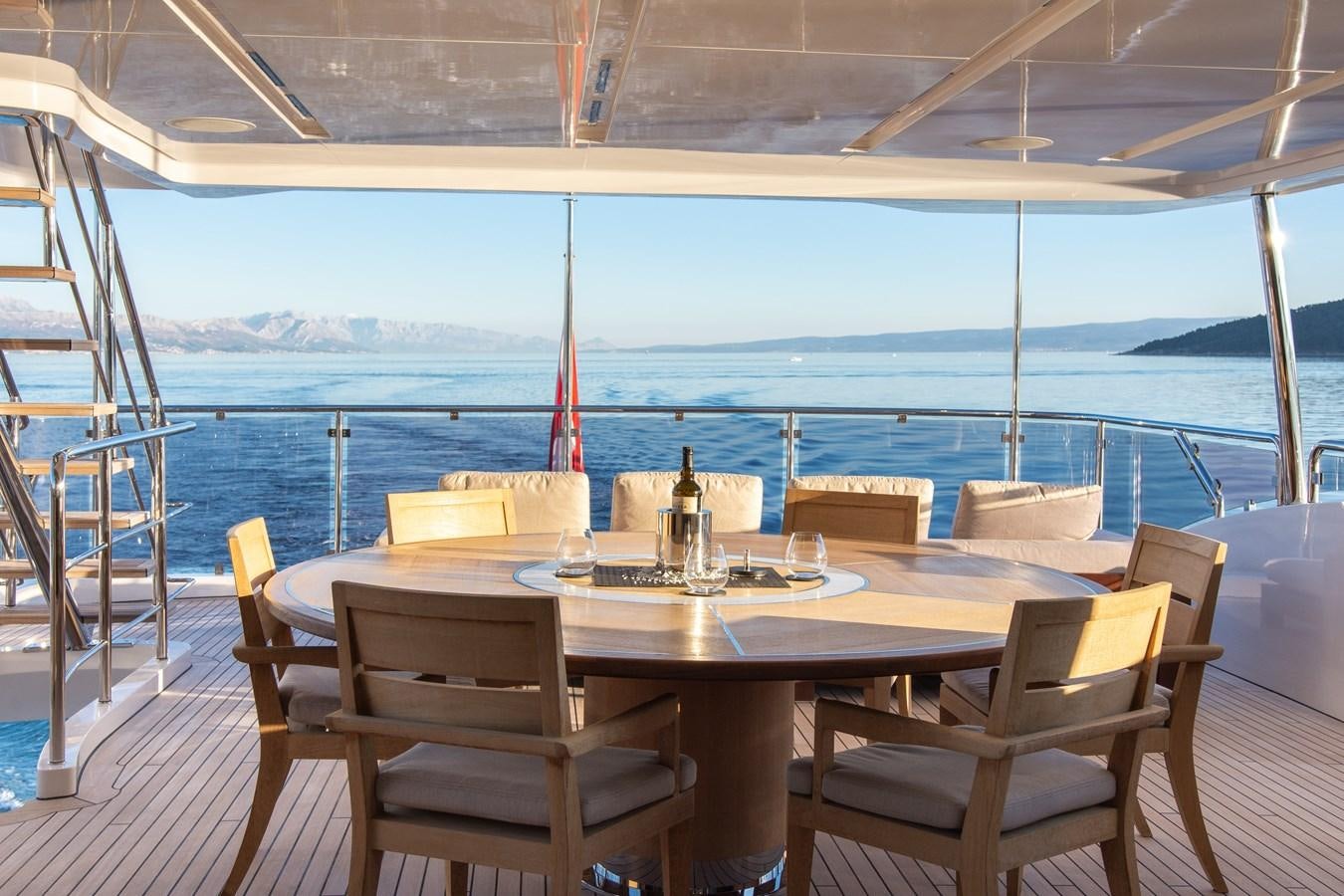 a table set for a meal on a deck overlooking the ocean aboard VARVARA Yacht for Sale