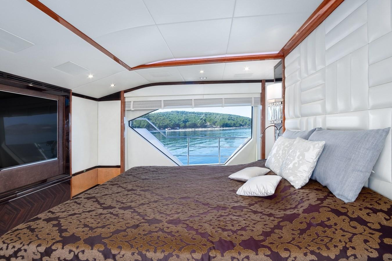 a bed with a large window aboard VARVARA Yacht for Sale
