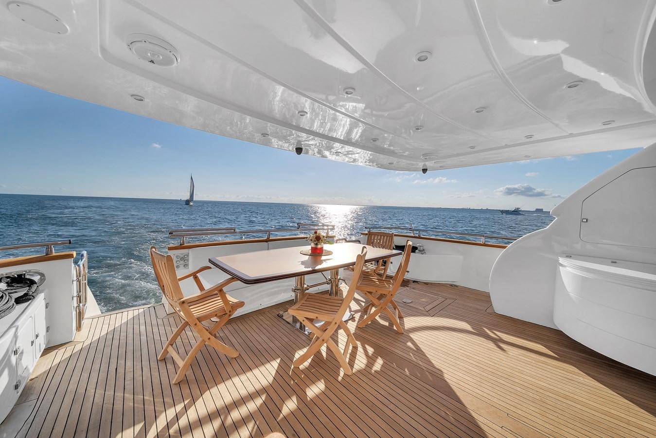 a deck with a table and chairs on it aboard DOMINIC Yacht for Sale