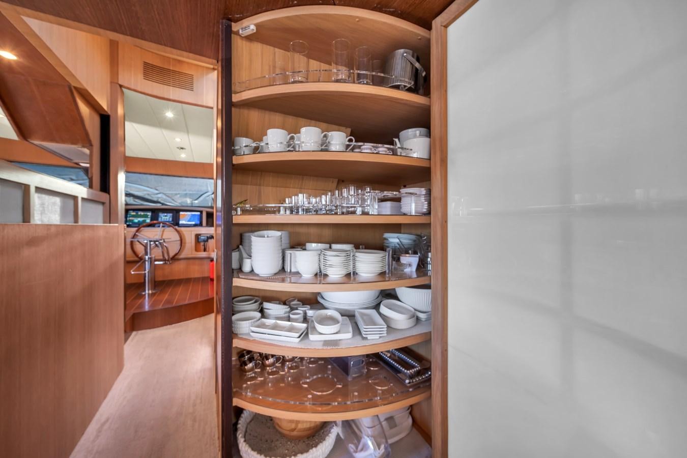 a wooden cabinet with a shelf of china aboard DOMINIC Yacht for Sale