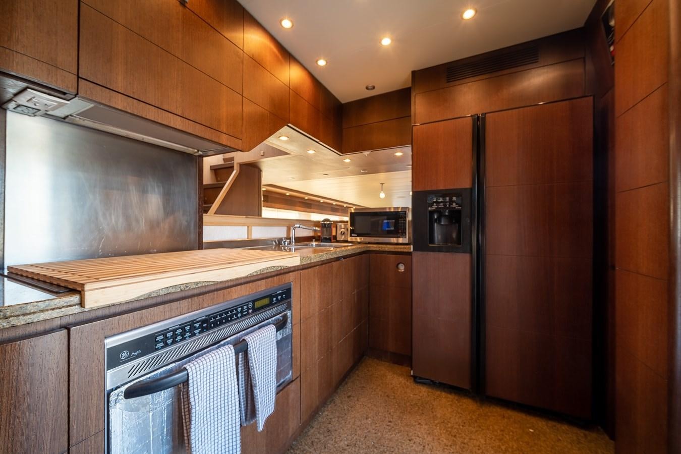 a kitchen with wooden cabinets aboard DOMINIC Yacht for Sale