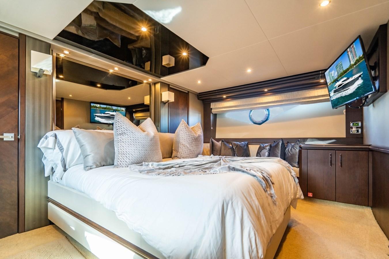 a bed with pillows and a television aboard MAYA Yacht for Sale