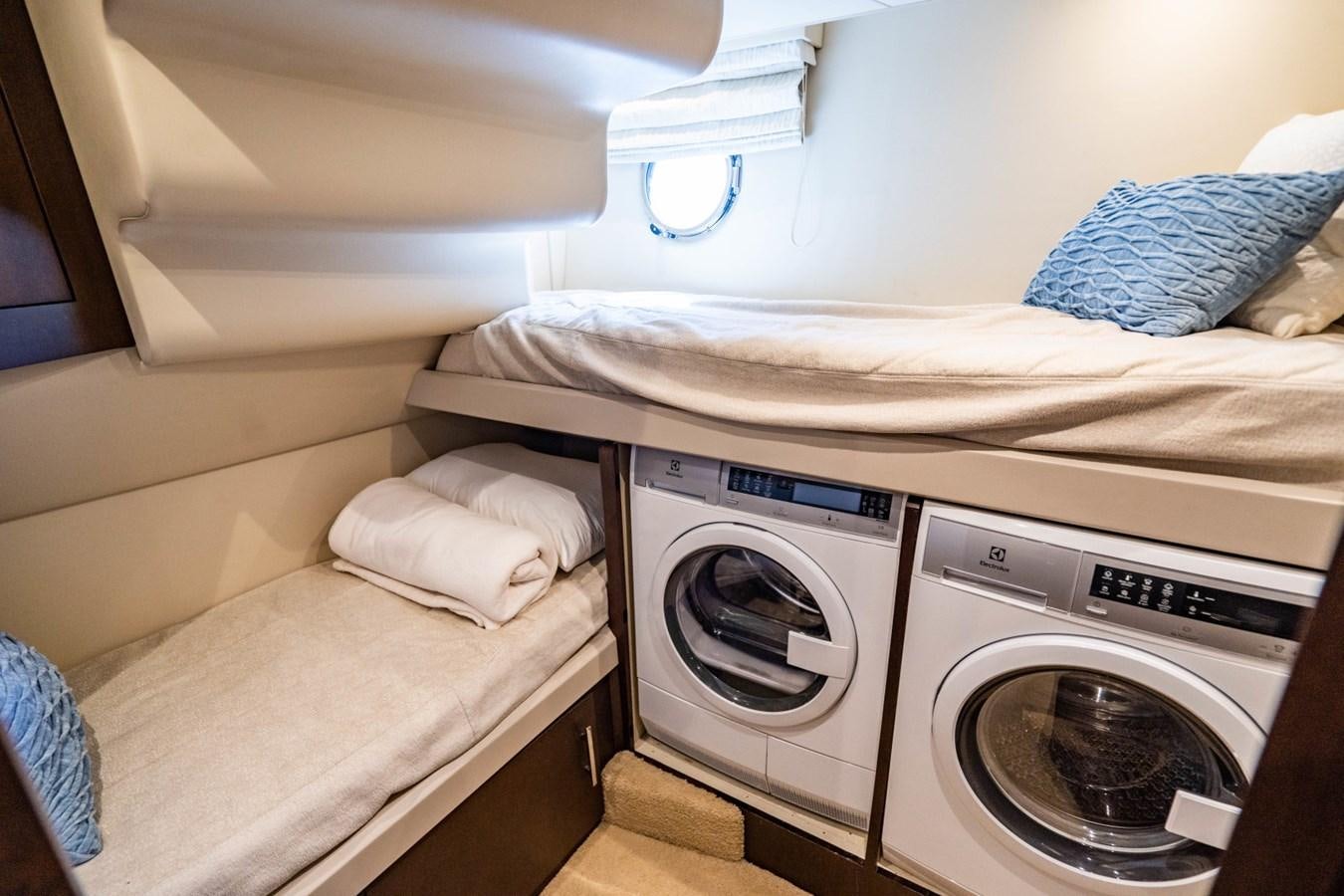 a small bedroom with a washing machine aboard MAYA Yacht for Sale