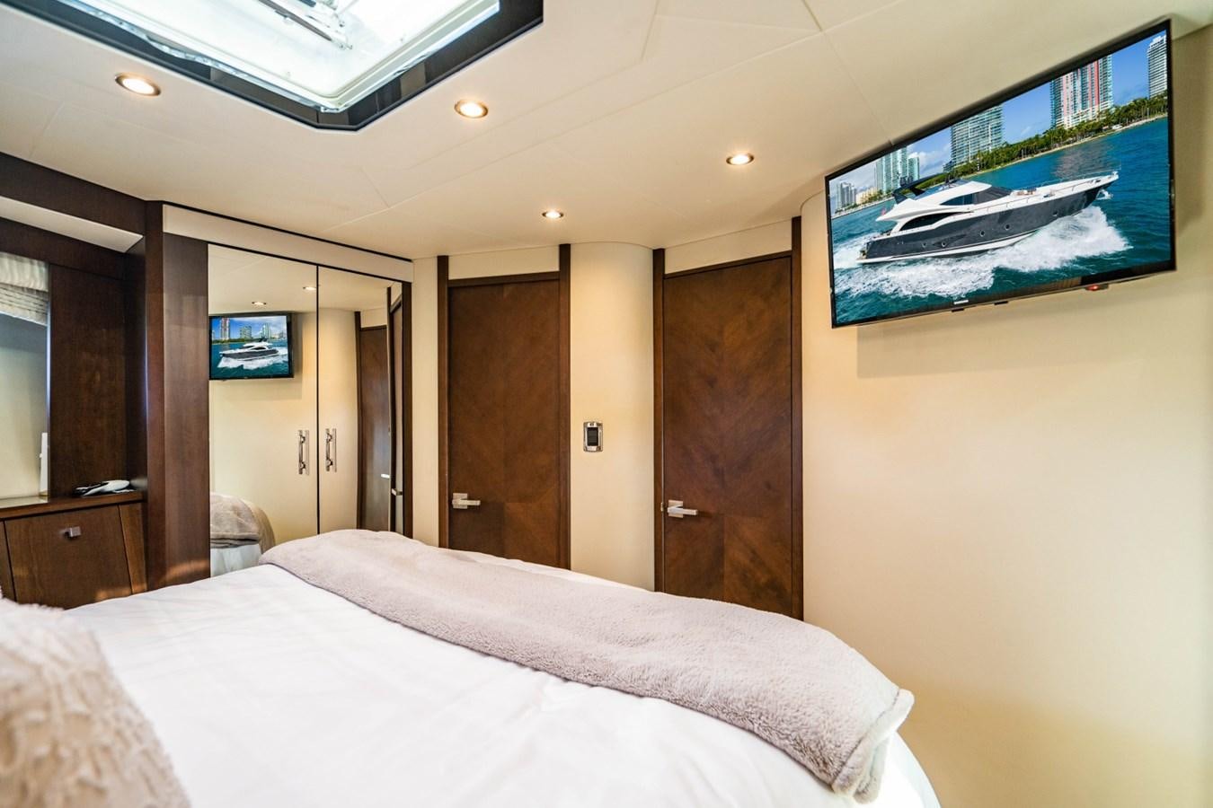 a bedroom with a bed and a television on the wall aboard MAYA Yacht for Sale